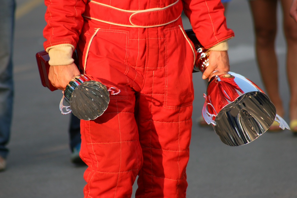 Detail,Of,Man,In,Racing,Overall,Holding,Two,Trophies.
